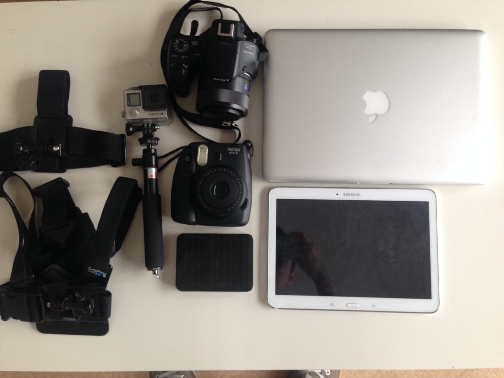 Photo d'un ordinateur, une gopro et un polaroid pour faire le tour du monde en voyage