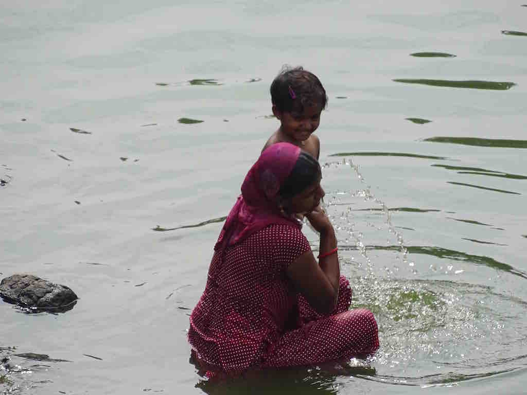 Une indienne et son enfant se baignent dans le bassin Banganga a Mumbai en Inde
