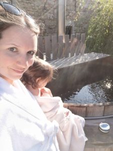 Une femme et son bébé devant un jaccuzi